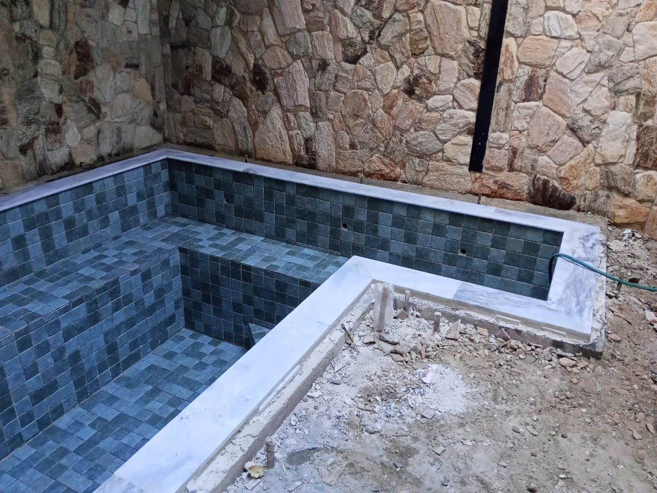 Piscina com pastilha escura em fase de acabamento
